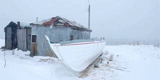 躲避暴风雨的庇护所，古老的渔村和冰岛暴风雪中的木船
