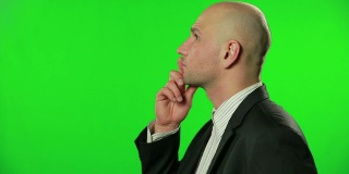一个在绿色屏幕前思考的商人的肖像