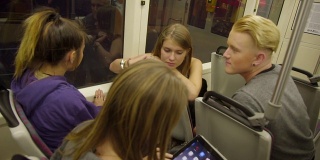 青少年在max列车上使用平板电脑