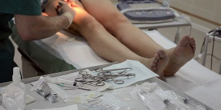 外科医生给病人做腿手术。把手术刀