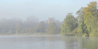 通过清晨的薄雾在一个美丽的湖