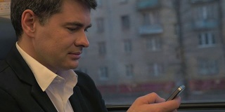 商人在火车上使用智能手机