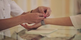珠宝店:年轻女子试戴昂贵的手镯。近距离