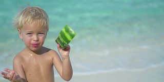孩子们在海滩上吃西瓜的慢动作视频