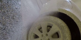 高压清洗机清洗车辆，在车辆表面喷洒清洁剂泡沫