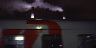 列车在夜间经过工厂