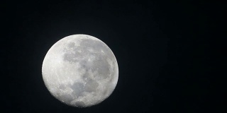 满月在多云的天空，夜间飞行云的高清镜头。