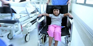 小女孩轮椅推着繁忙的医院走廊