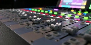 一个音频混音器的录像，镜头从右向左移动，旋钮会自动上下拉动