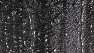 水滴在黑色的皮革表面。视频素材模板下载
