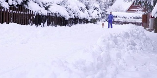 小猎犬走在雪山村里的小路上