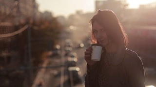 美丽的女人在城市桥上喝咖啡视频素材模板下载
