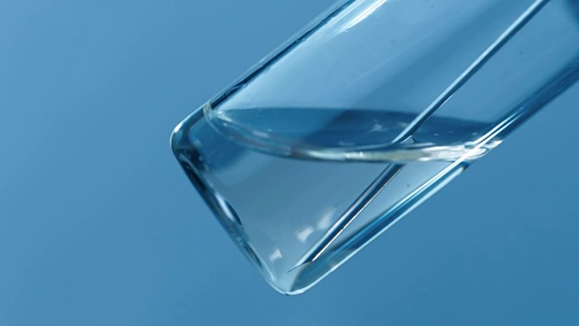 注射器的针头从蓝色背景的玻璃药瓶中取出药物