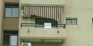公寓阳台上的出售标志。房地产中介服务。
