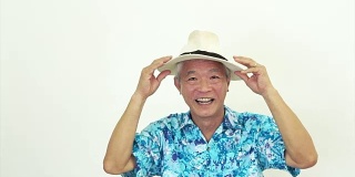 亚洲老人穿着蓝色夏威夷衬衫和帽子。准备好去度假了吗