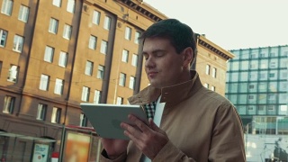 带着平板电脑的人在城市里行走视频素材模板下载