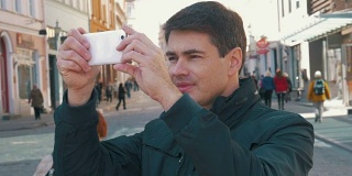 男游客在塔林大街上拍照