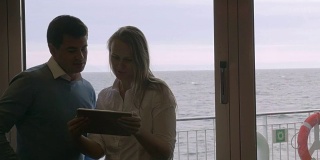 一对年轻夫妇在船上使用平板电脑