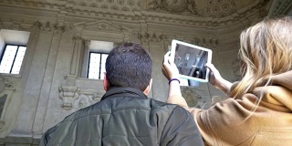 两个人在古建筑内用pad拍照
