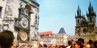 人们走过天文钟和布拉格市中心的旧时代广场的时间流逝。