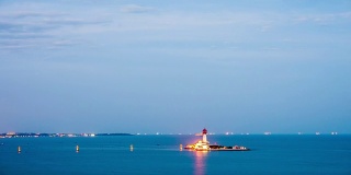 Beautiful sunset on coastline with powerful lighted lighthouse. Beidaihe, China.