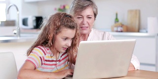 孩子和奶奶一起使用笔记本电脑