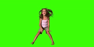 快乐的女孩在绿色的屏幕上跳上跳下