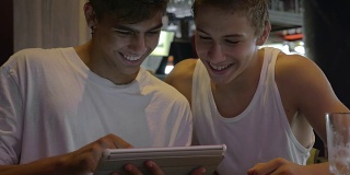两个青少年在咖啡馆里用平板电脑