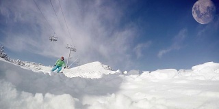 一个滑雪者滑下斜坡的慢动作动态镜头:雪花飞进了摄像机