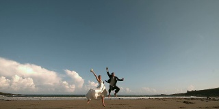 快乐的新婚夫妇在空中跳跃