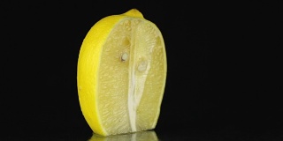一半柠檬，在黑色背景上旋转