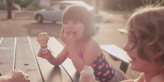 一家人在野餐桌上吃着冰淇淋玩得很开心