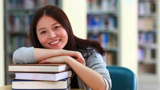 漂亮的亚洲女大学生在图书馆视频素材模板下载