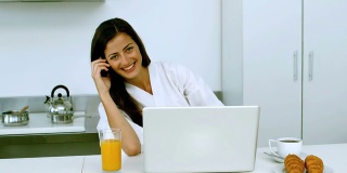 微笑的女人在电话里吃早餐
