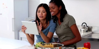 年轻女性在平板电脑上浏览网上菜谱