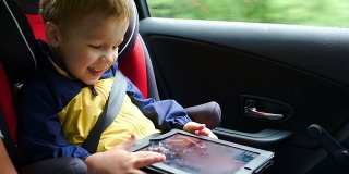 小男孩在车里玩平板电脑