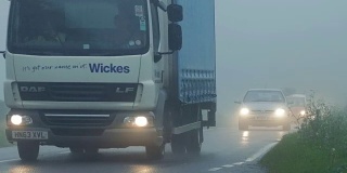 小汽车、货车和卡车在浓雾中通行