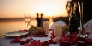 日落时分，一对情侣在海滩餐厅浪漫约会