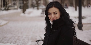 woman in winter park sitting on the bench