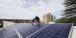 太阳能技术员在屋顶上安装太阳能电池板。