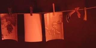 小男孩的黑白照片在暗室里用绳子晒干