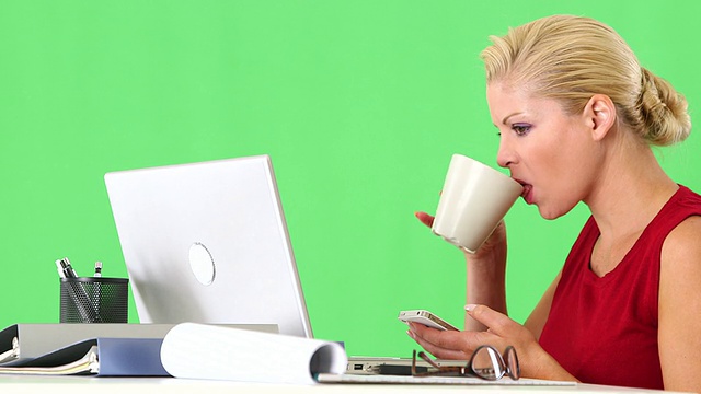 Businesswoman working with cellphone and laptop at desk