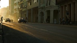 哈瓦那夕阳下的行人和老爷车视频素材模板下载