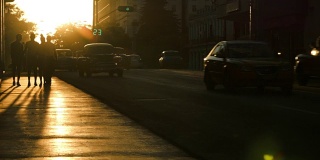 夕阳下的行人和汽车在哈瓦那的剪影
