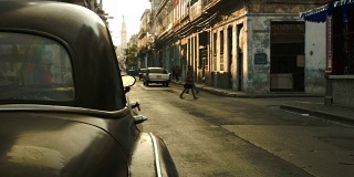 一辆美国老爷车在哈瓦那的老街上驶过