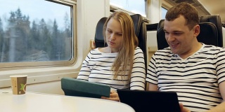 年轻人在火车上一边看平板电脑一边说话