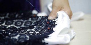 女裁缝缝制一件有饰针的衣服