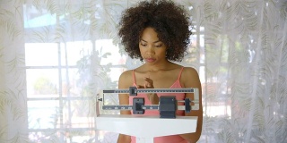 一名年轻女子在磅秤上记录体重减轻