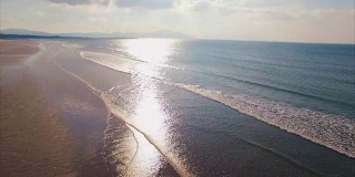 无人机拍摄的日落时分海浪到达海滩的画面