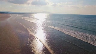 无人机拍摄的日落时分海浪到达海滩的画面视频素材模板下载